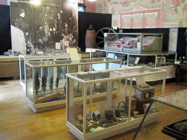 The Mining Room: glass cases of mining tools, a mine model and a large photograph of miners
